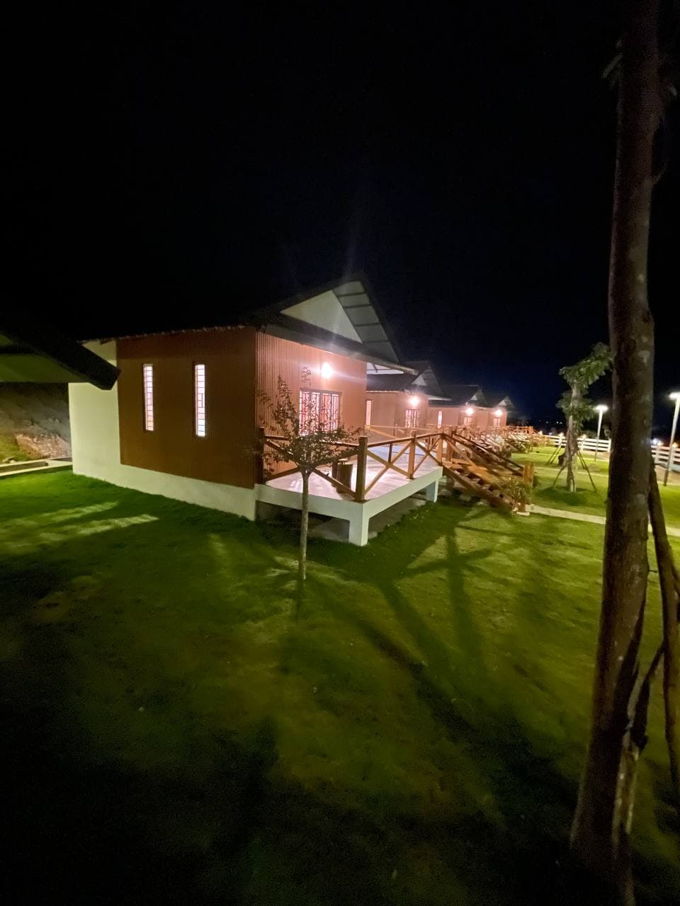 Bungalow exterior with wooden stairs and warm lighting