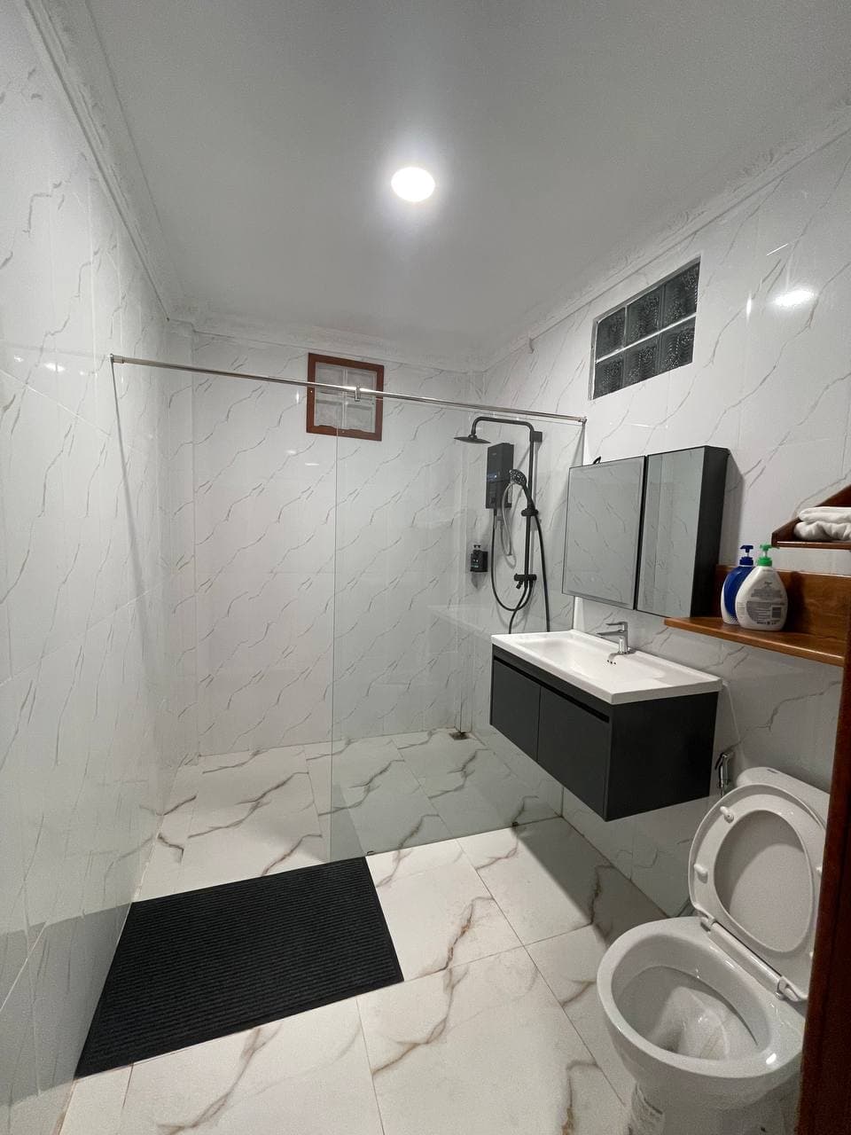 Modern bathroom with glass shower and marble tile